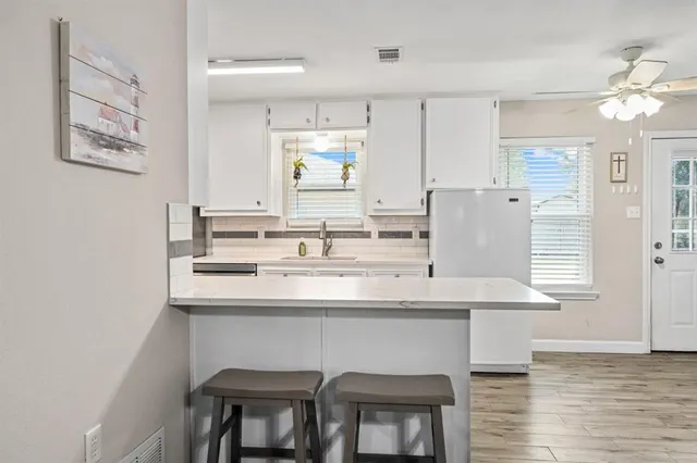 a kitchen with stainless steel appliances granite countertop a sink and a refrigerator