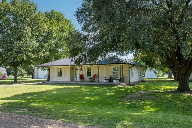 a view of a house with a yard and sitting area
