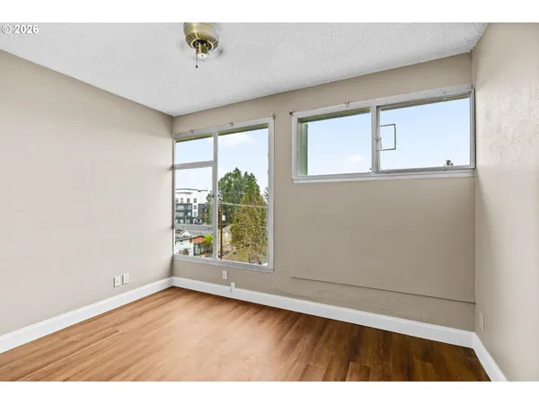an empty room with wooden floor and windows