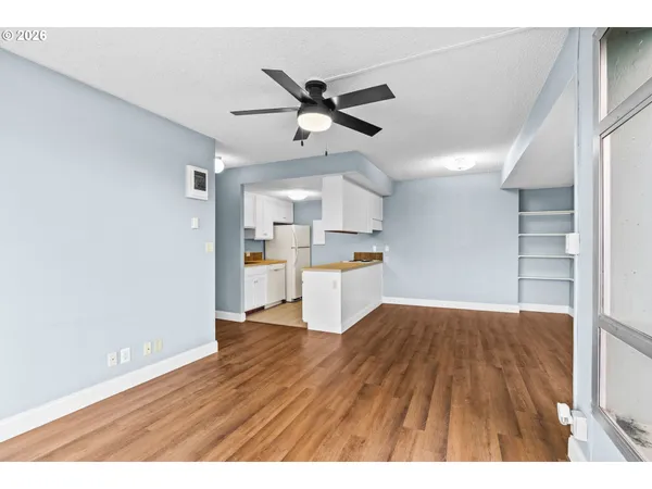 a view of empty room with wooden floor and window