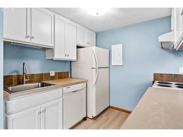 a kitchen with stainless steel appliances granite countertop a refrigerator sink and white cabinets