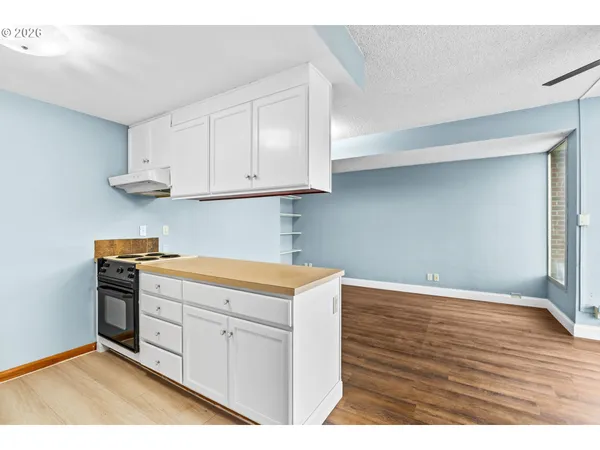 a kitchen with stainless steel appliances granite countertop a stove a sink and white cabinets
