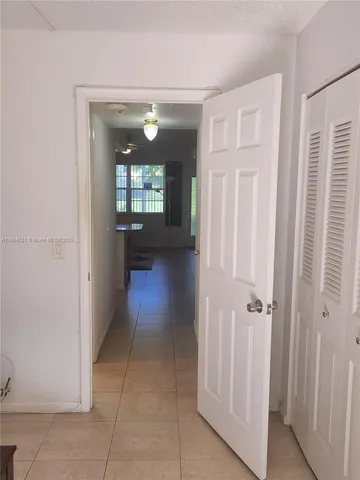 a view of a hallway with wooden floor and a livingroom