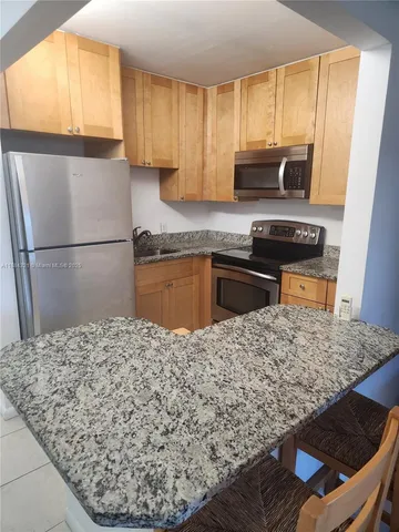 a kitchen with a refrigerator sink and stove