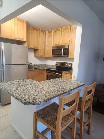 a kitchen with a stove a sink and a refrigerator