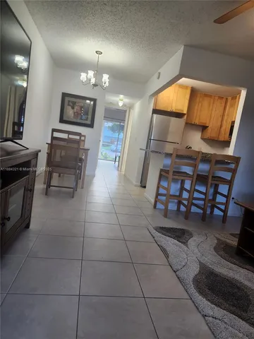 a open kitchen with granite countertop a stove a sink and a dining table
