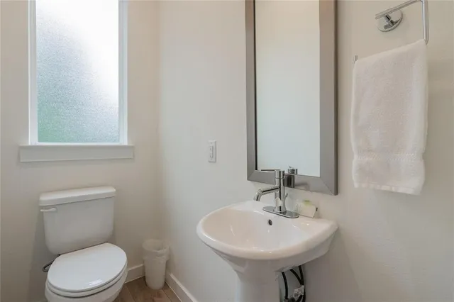 a bathroom with a sink a toilet and mirror