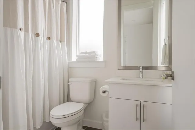 a bathroom with a toilet a sink and a mirror