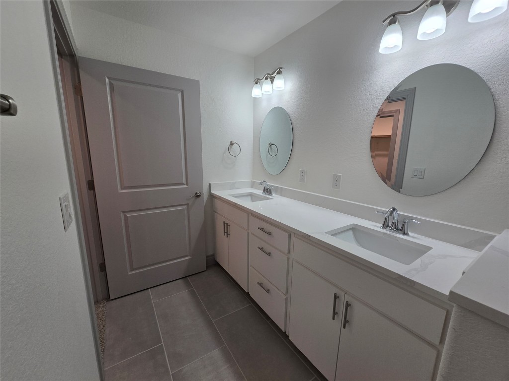 2105 Tiger Trail, Unit 702 Round Rock, TX 78664 - Photo 16 of 22 a spacious bathroom with a double vanity sink and a mirror