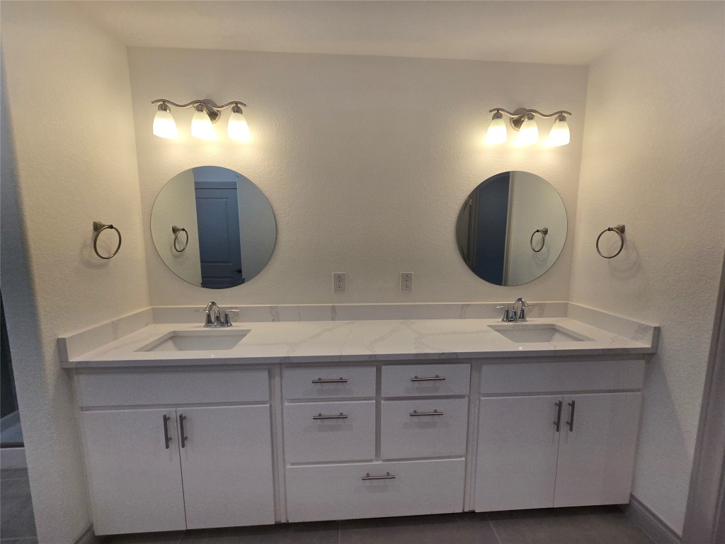2105 Tiger Trail, Unit 702 Round Rock, TX 78664 - Photo 8 of 22 a bathroom with double vanity sinks and a mirror