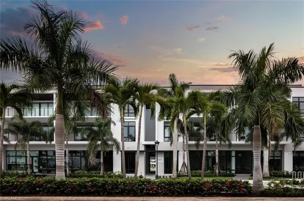 a front view of multi story residential apartment building with yard and green space