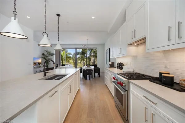 a kitchen with stove a sink and cabinets