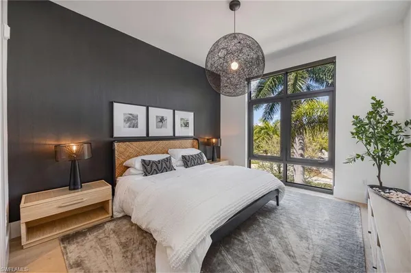 a bedroom with a large bed and a chandelier