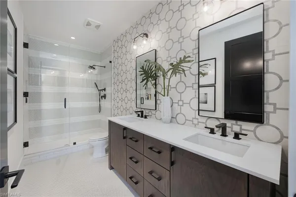 a bathroom with a double vanity sink mirror and shower