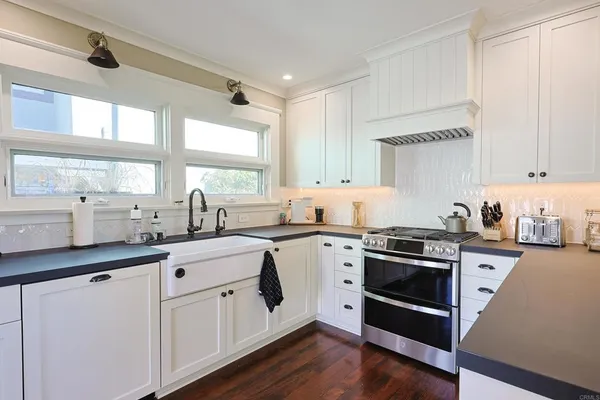 a kitchen with granite countertop white cabinets and white appliances