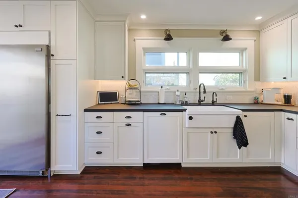 a kitchen with stainless steel appliances a sink cabinets and wooden floor