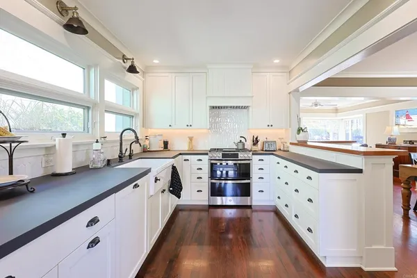 a kitchen with granite countertop a sink stove and cabinets