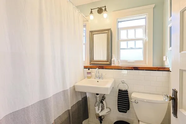 a bathroom with a sink a toilet and a mirror