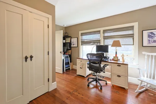 a view of a workspace with furniture and a window