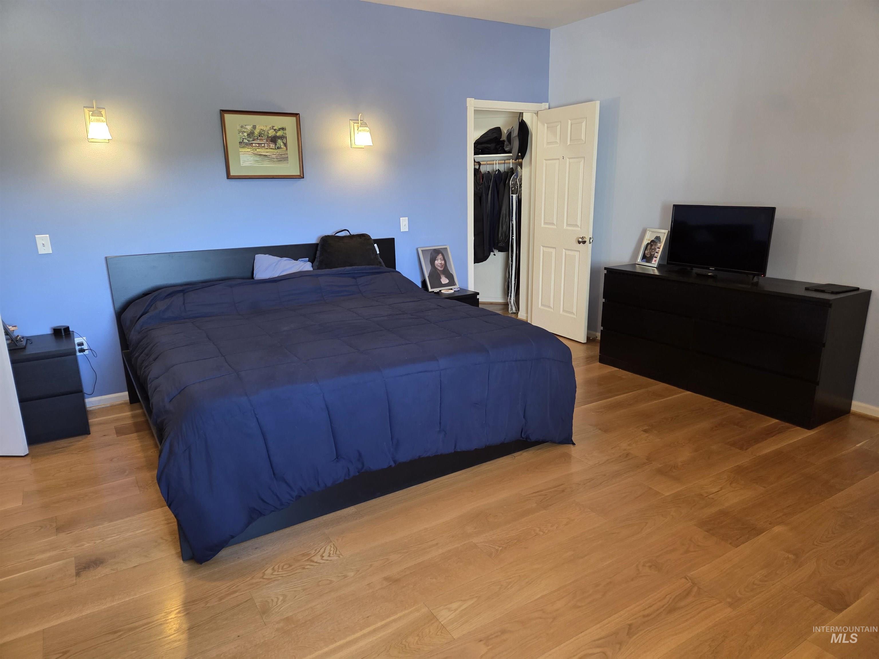 1085 Wallen Road Moscow, ID 83843 - Photo 23 of 50 Room featuring wood-finish flooring, two wall-mounted sconces, and a built-in closet with a white paneled door