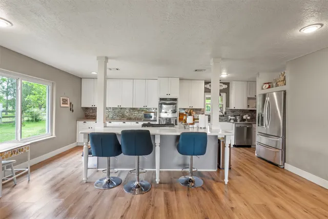 a kitchen with a dining table chairs refrigerator and cabinets