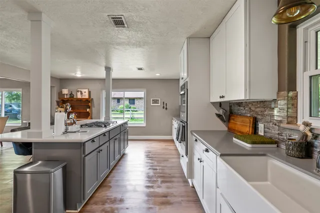 a kitchen with stainless steel appliances a sink stove and cabinets