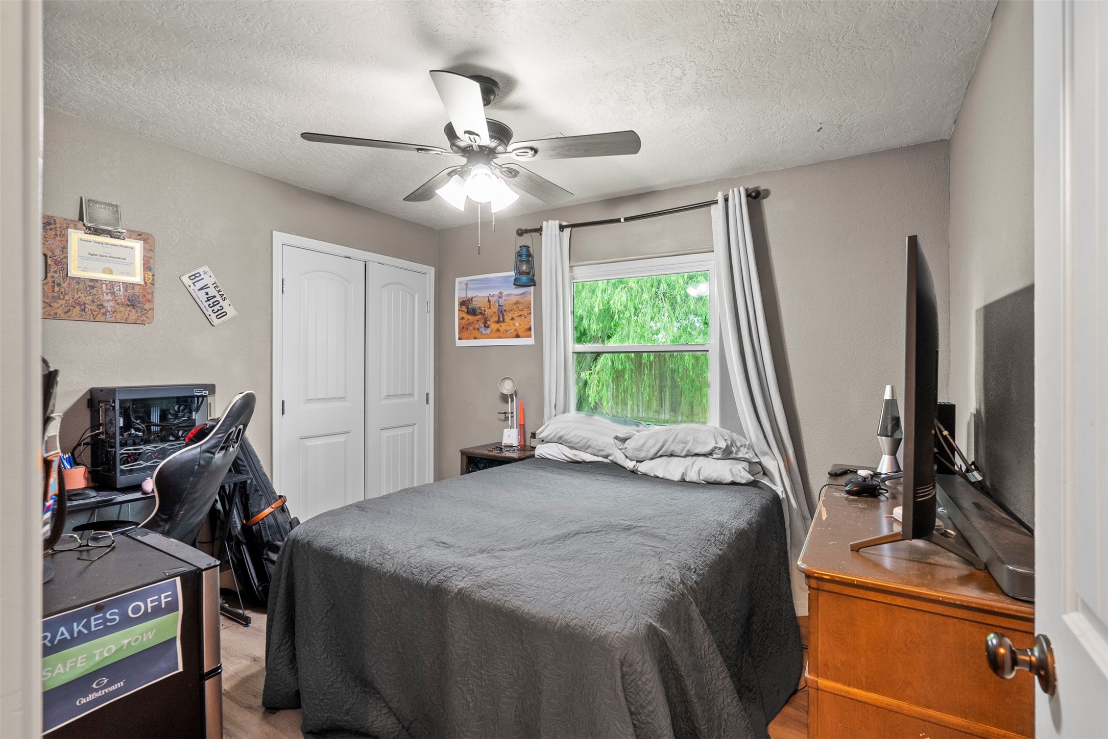 5211 Ghinaudo Road Hitchcock, TX 77563 - Photo 22 of 34 a bedroom with a bed and a flat tv screen on dresser