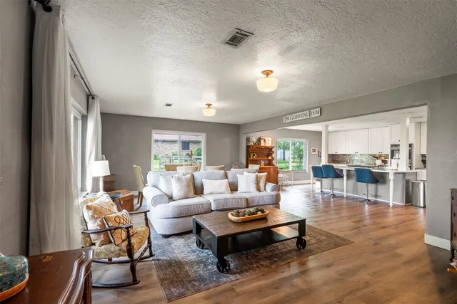 a living room with furniture and wooden floor