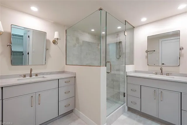 a bathroom with a double vanity sink mirror and shower