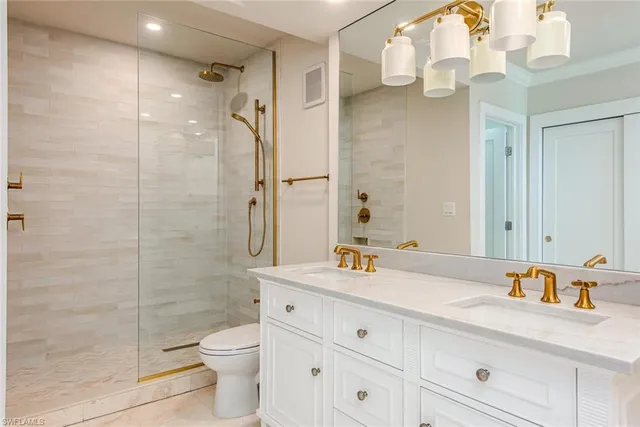 a bathroom with a granite countertop sink toilet a large mirror a shower and vanity