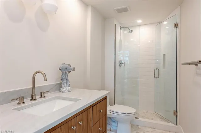 a bathroom with a granite countertop sink toilet and shower