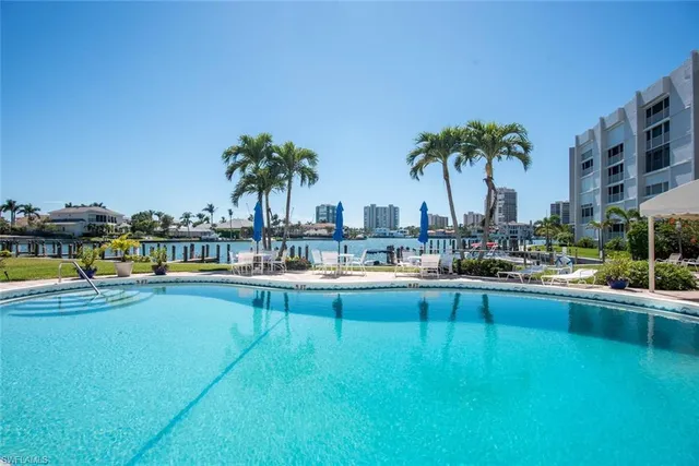a view of swimming pool with outdoor seating and lake view