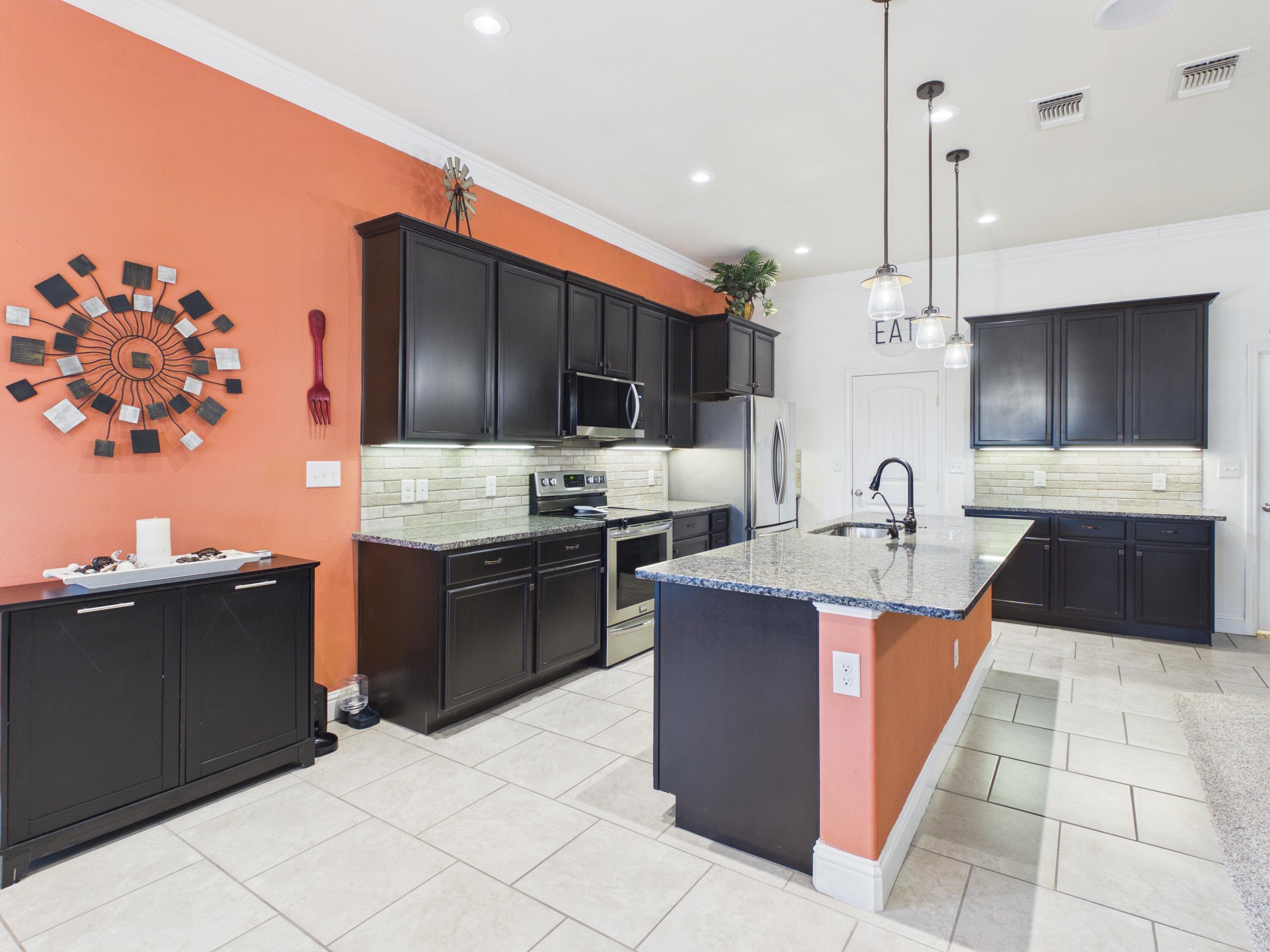 7101 94th Street Lubbock, TX 79424 - Photo 16 of 33 a large kitchen with stainless steel appliances kitchen island granite countertop a sink and cabinets