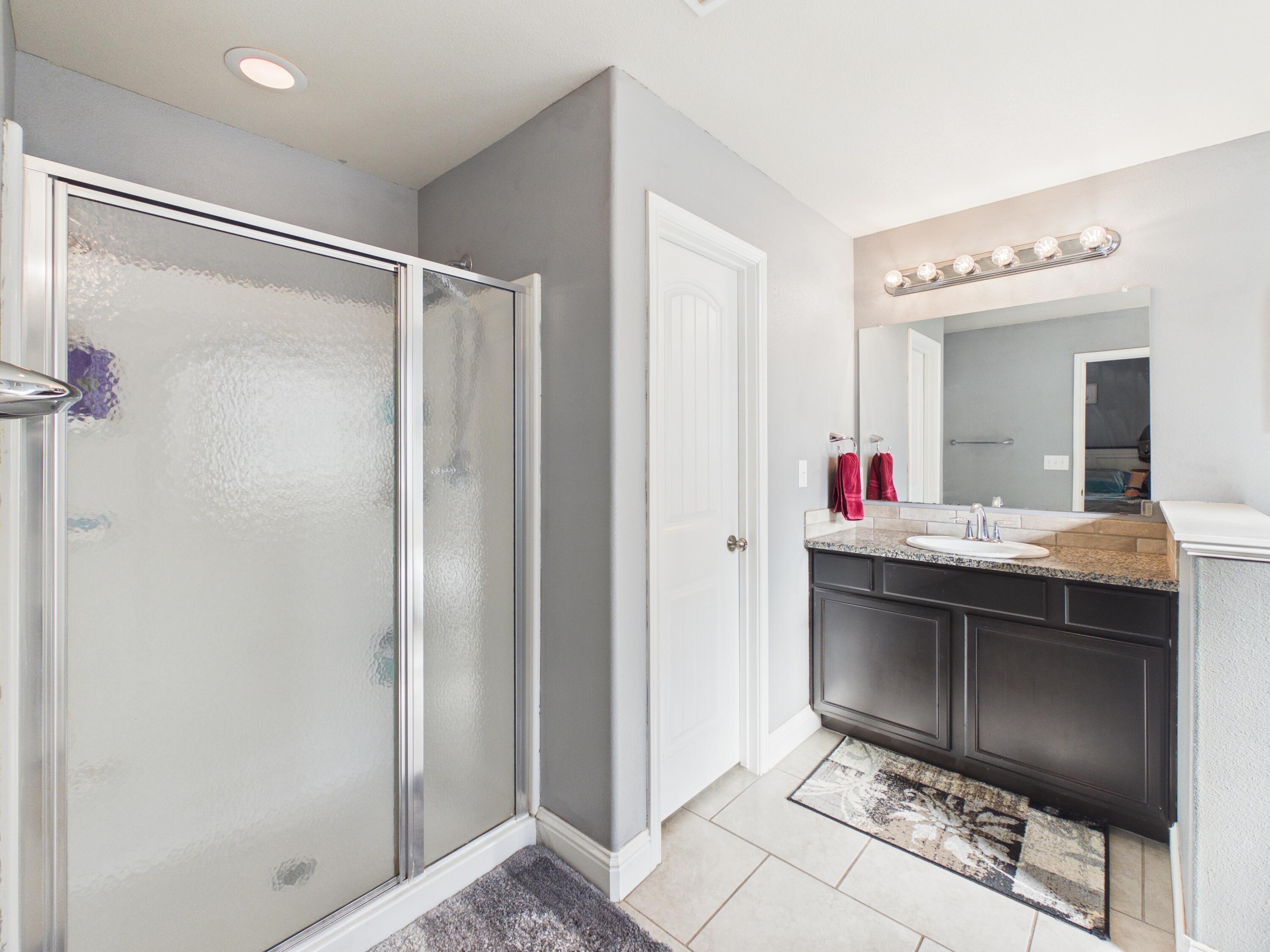 7101 94th Street Lubbock, TX 79424 - Photo 24 of 33 a en suite bathroom with a shower sink and mirror