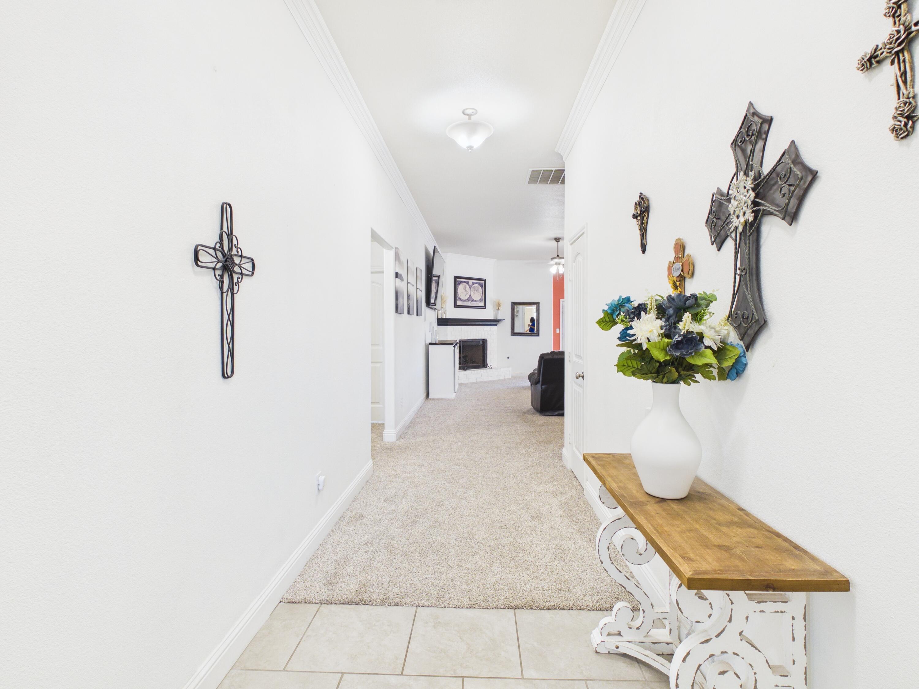 7101 94th Street Lubbock, TX 79424 - Photo 3 of 33 a hallway with a potted plant on the counter and a sink