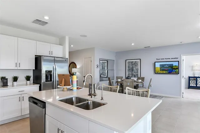 a kitchen with stainless steel appliances granite countertop a potted plant on the counter and a refrigerator