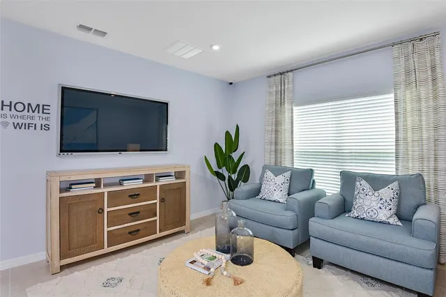 a living room with furniture kitchen view and a wooden floor