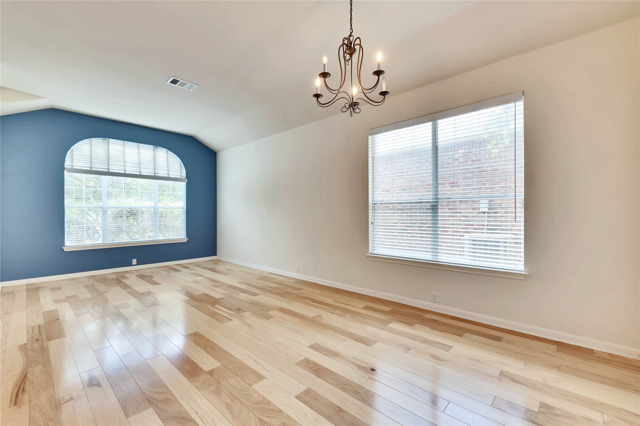 2133 Paradise Ridge Drive Round Rock, TX 78665 - Photo 8 of 22 Vaulted ceiling room featuring light wood-finish flooring, a large arched window with horizontal blinds, and a traditional chandelier