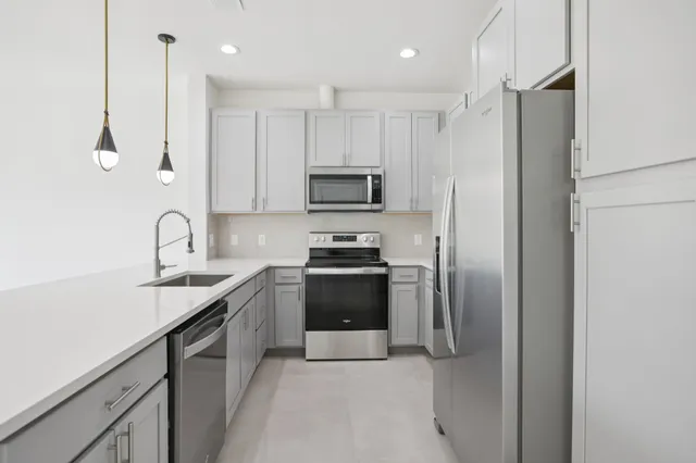 a kitchen with stainless steel appliances granite countertop a refrigerator and a stove top oven