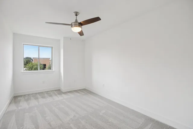 an empty room with closet and ceiling fan