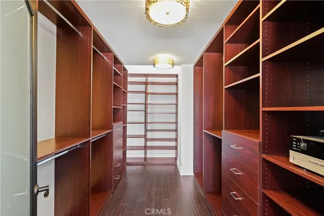 a view of walk in closet with clothes and shoes