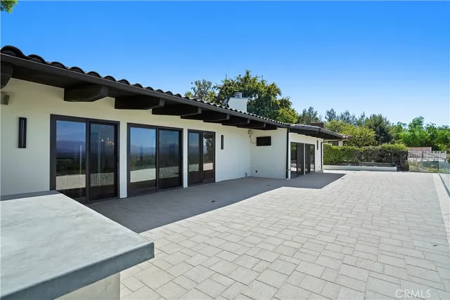 a view of house with backyard and glass windows