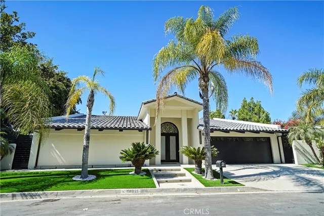 a front view of a house with garden and parking area
