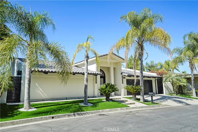 a front view of a house with garden and trees