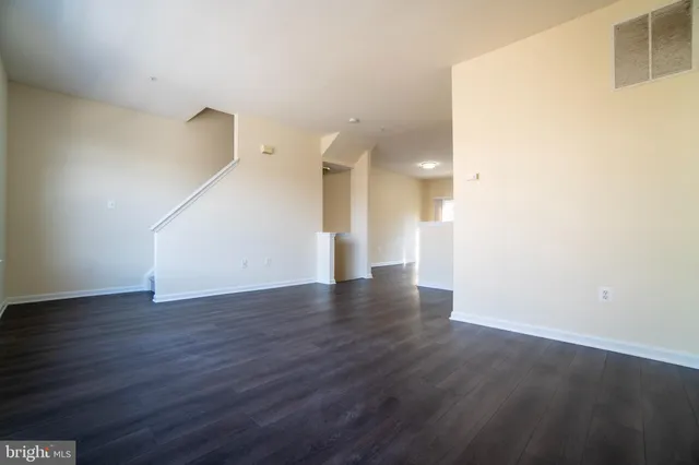 a view of a room with wooden floor and white walls