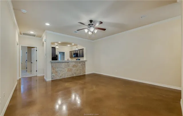 wooden floor in an empty room with a kitchen