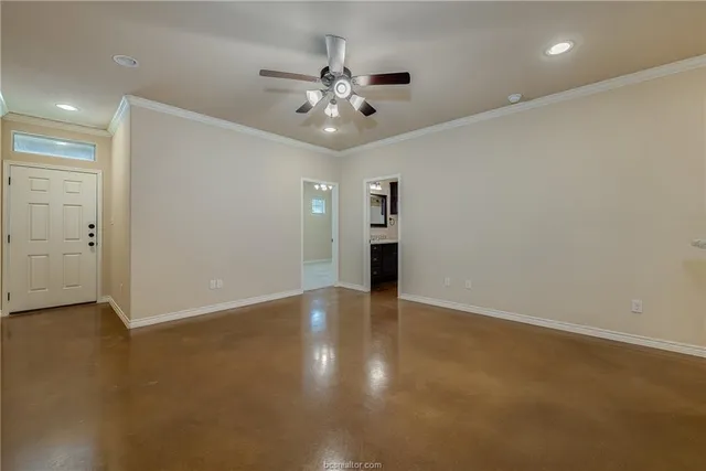 an empty room with fan and entrance