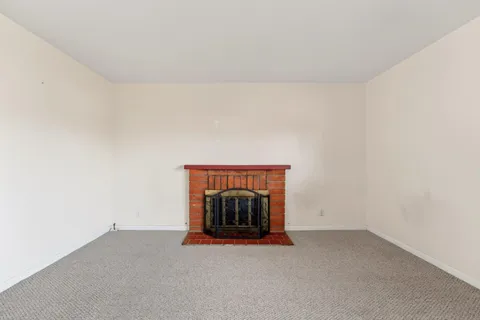 a view of an empty room and a fireplace