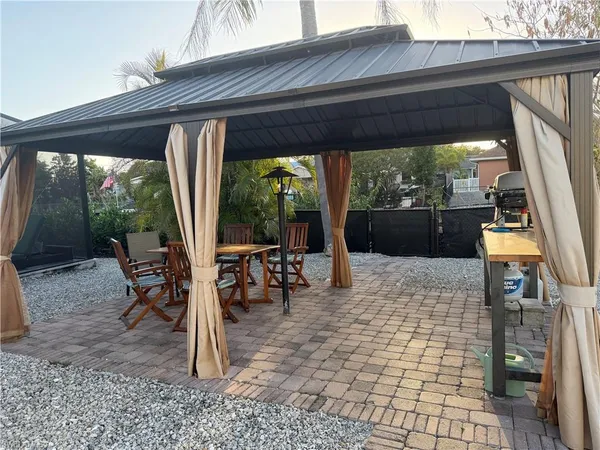 a view of a patio with a table chairs and a backyard