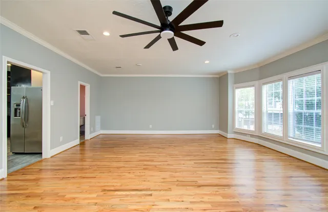 a view of an empty room with window and wooden floor